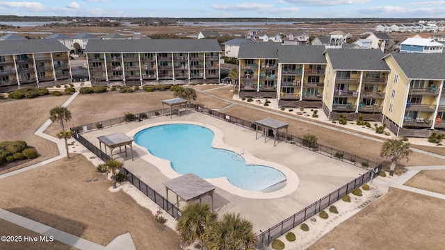 community pool with fence and a residential view