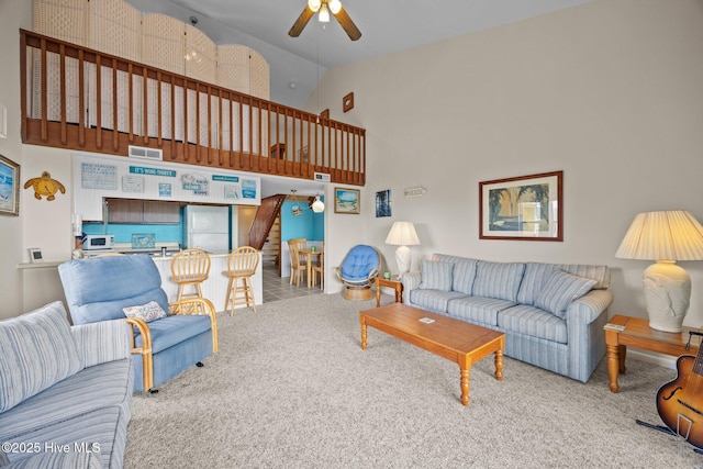 living room featuring carpet floors, visible vents, high vaulted ceiling, and a ceiling fan