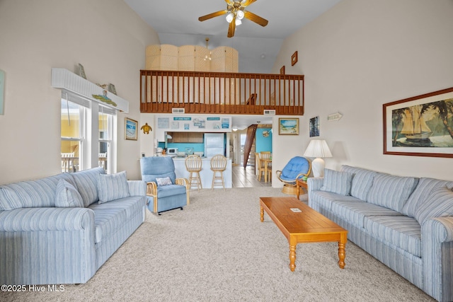 living area with carpet, high vaulted ceiling, and ceiling fan