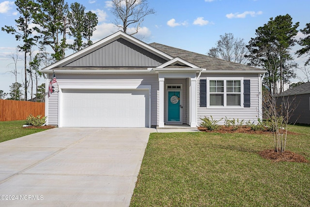 view of front of home with a garage, driveway, fence, and a front yard