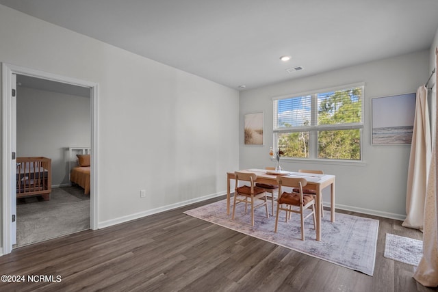 dining room featuring dark wood-style floors, visible vents, and baseboards