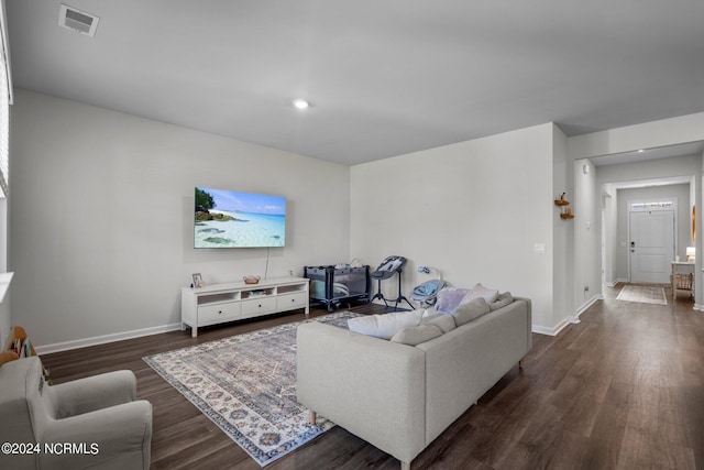 living room featuring dark wood finished floors, visible vents, and baseboards