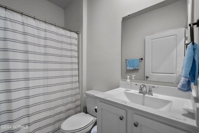 full bath featuring toilet, curtained shower, and vanity