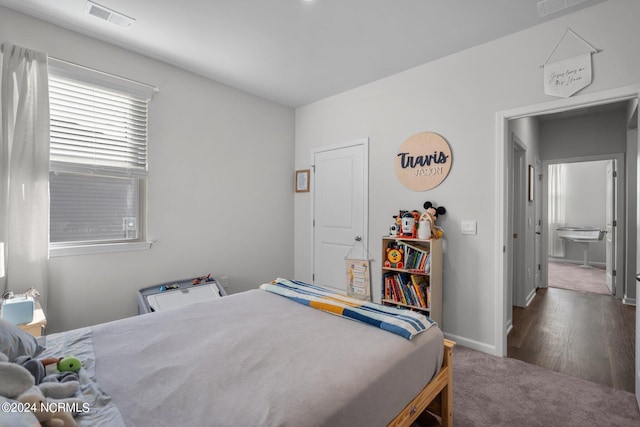 carpeted bedroom with visible vents and baseboards