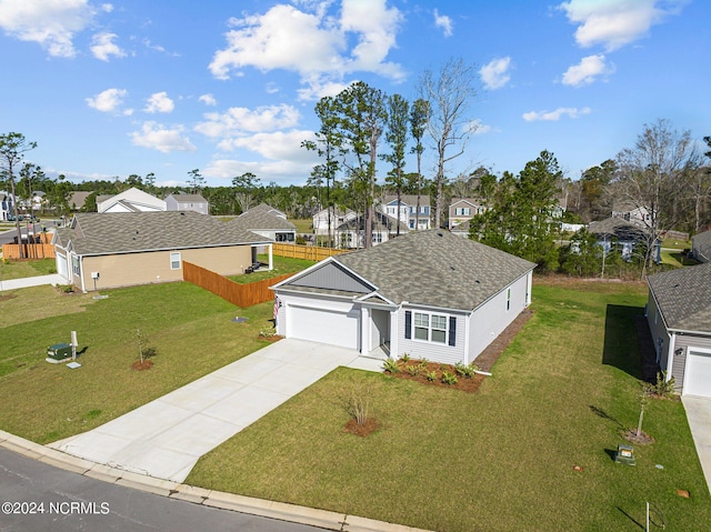 view of front of house featuring a garage, fence, concrete driveway, a residential view, and a front yard