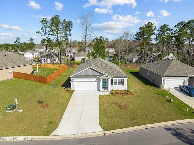 ranch-style home with a residential view, an attached garage, driveway, and a front lawn