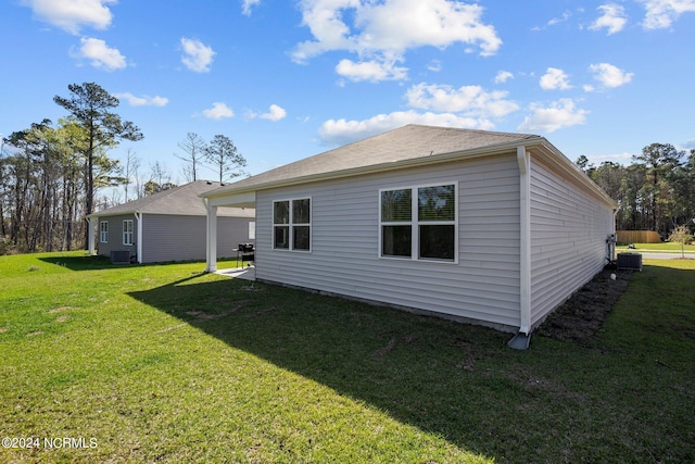 back of house with cooling unit and a yard