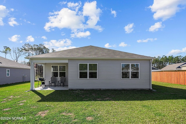 back of property featuring a patio area, fence, a lawn, and roof with shingles