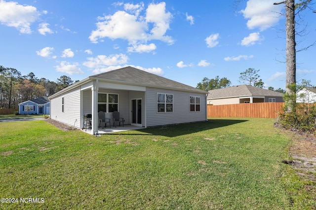 back of property featuring a yard, a patio area, and fence