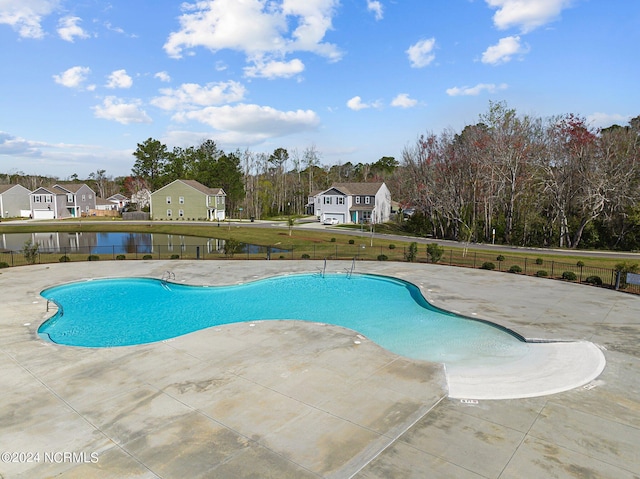 pool with a patio and fence