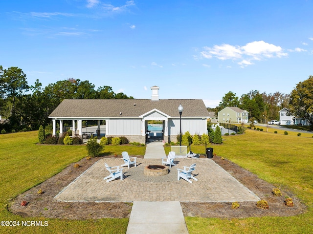 view of front of house with an outdoor fire pit, a patio, and a front lawn