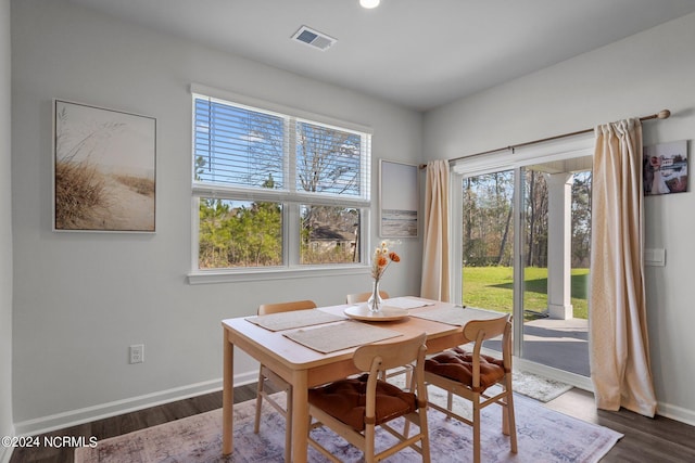 dining room featuring baseboards, visible vents, and dark wood-style flooring