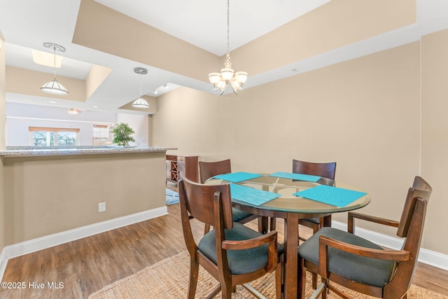 dining room featuring an inviting chandelier, baseboards, and wood finished floors