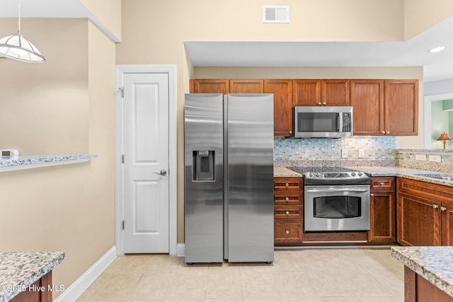 kitchen with stainless steel appliances, tasteful backsplash, visible vents, light tile patterned flooring, and a sink