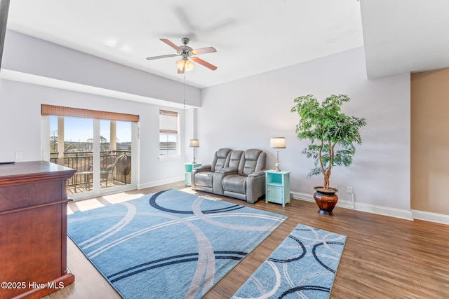 living area with ceiling fan, baseboards, and wood finished floors