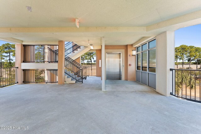 view of patio with elevator and stairway