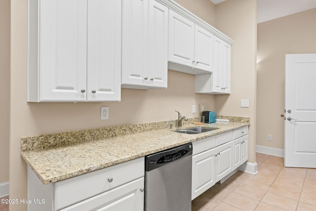 kitchen featuring light tile patterned flooring, a sink, white cabinets, light stone countertops, and dishwasher