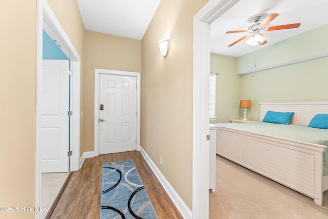 interior space featuring ceiling fan, baseboards, and wood finished floors