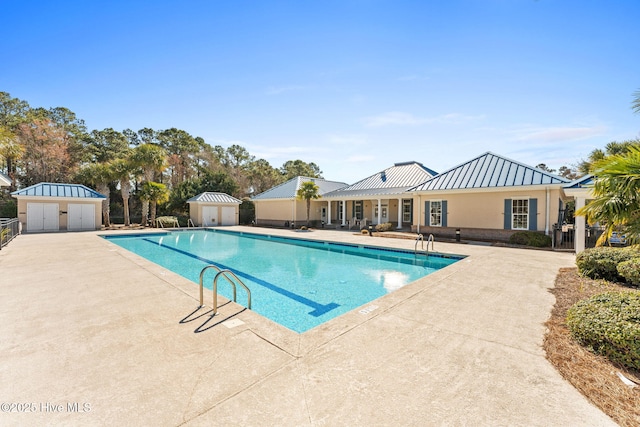 pool with a patio area, fence, an outdoor structure, and a shed