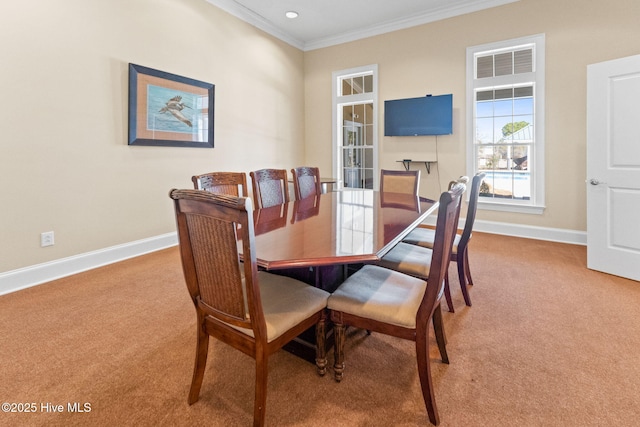 carpeted dining area with ornamental molding and baseboards