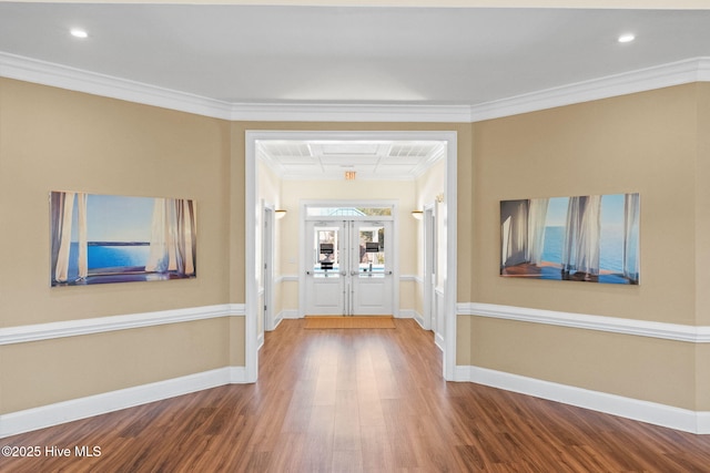 corridor featuring ornamental molding, baseboards, and wood finished floors