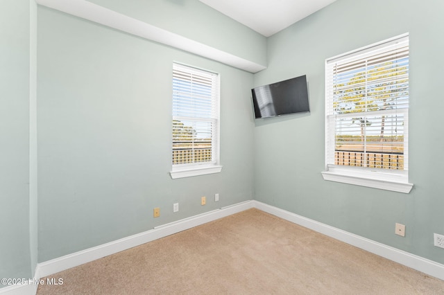 carpeted empty room with baseboards