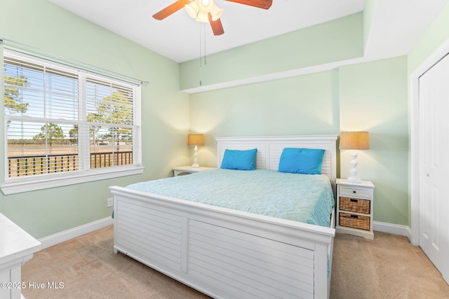 bedroom featuring a closet, light colored carpet, and baseboards