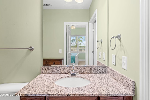 bathroom with visible vents, toilet, and vanity