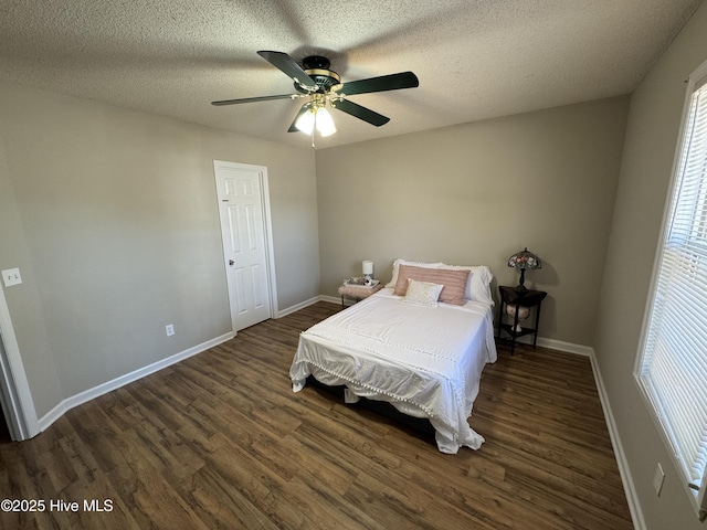 bedroom featuring ceiling fan, a textured ceiling, baseboards, and wood finished floors