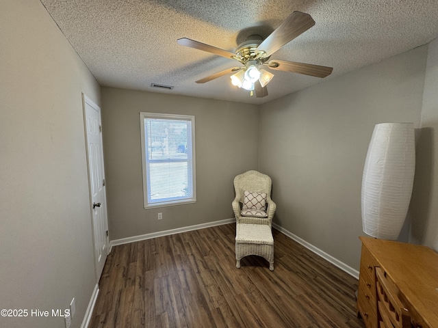 unfurnished room featuring a textured ceiling, ceiling fan, wood finished floors, and baseboards