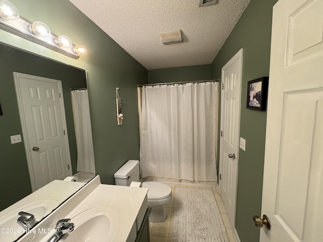 bathroom with a textured ceiling, curtained shower, tile patterned flooring, toilet, and vanity