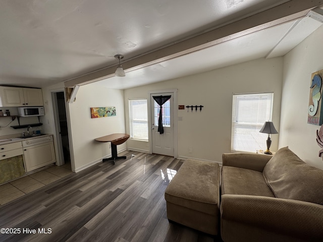 living area with baseboards, vaulted ceiling, and dark wood-style flooring