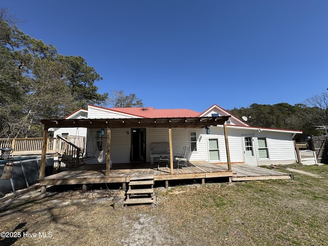 back of property with metal roof and a deck