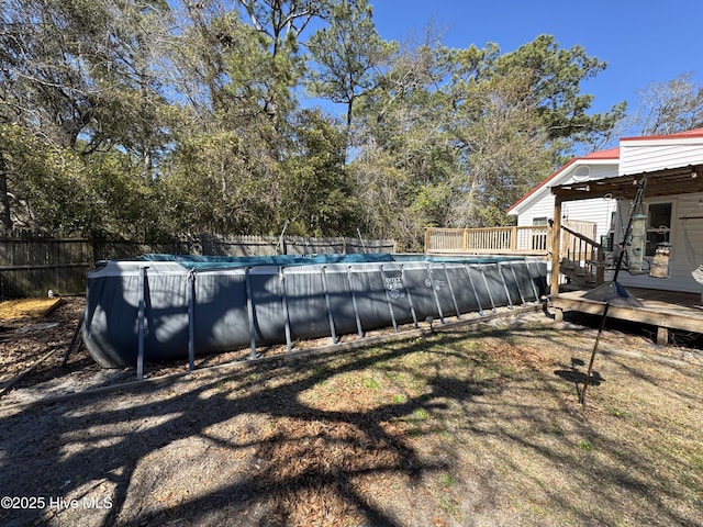 view of pool with fence, a fenced in pool, and a wooden deck