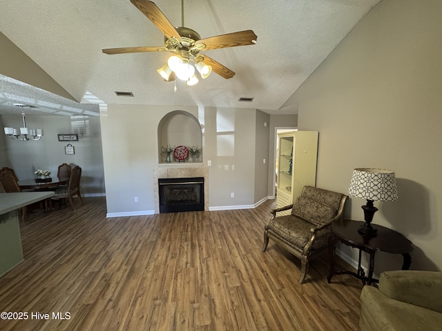 living room with a textured ceiling, visible vents, and wood finished floors