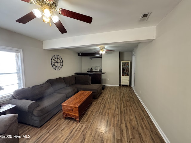 living area with a ceiling fan, baseboards, visible vents, and wood finished floors