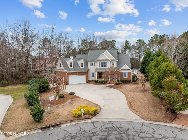 view of front of home with driveway, an attached garage, and brick siding