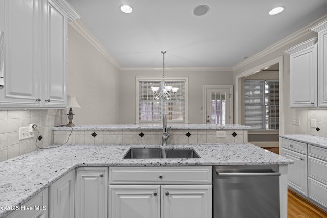 kitchen with crown molding, backsplash, a sink, wood finished floors, and dishwasher