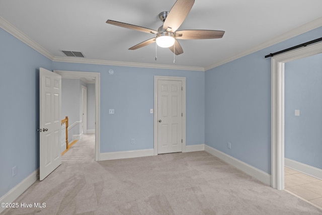 unfurnished bedroom with baseboards, ornamental molding, visible vents, and light colored carpet