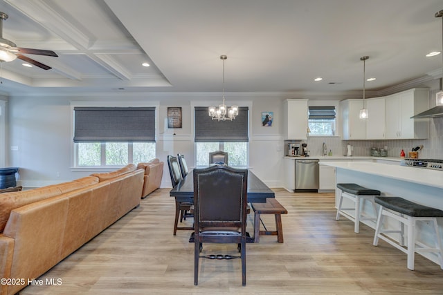 dining room with beam ceiling, crown molding, light wood-style flooring, coffered ceiling, and ceiling fan with notable chandelier