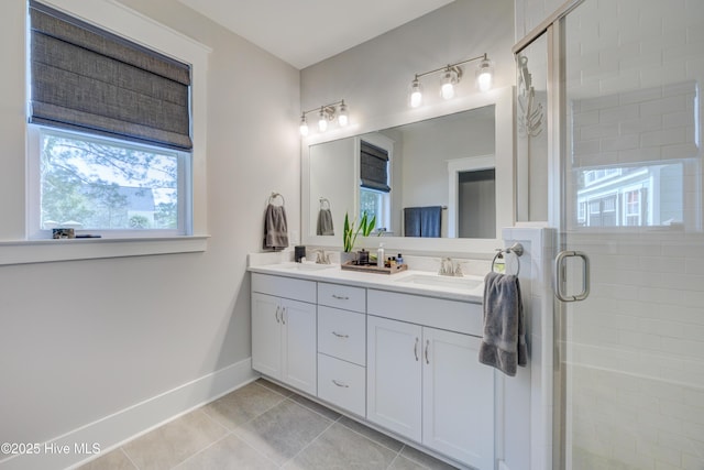 bathroom featuring tile patterned flooring, a sink, baseboards, double vanity, and a stall shower