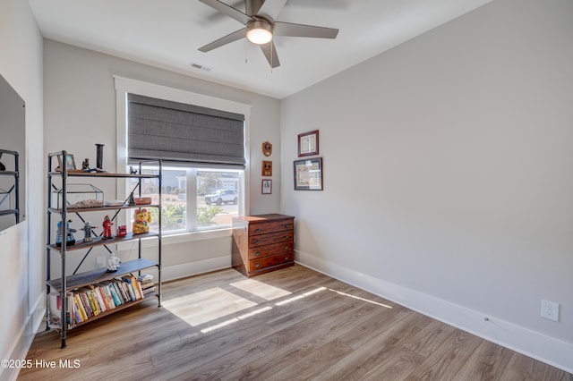 bedroom with ceiling fan, wood finished floors, visible vents, and baseboards