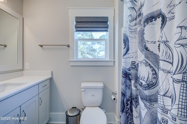 full bath with toilet, baseboards, a shower with shower curtain, and vanity