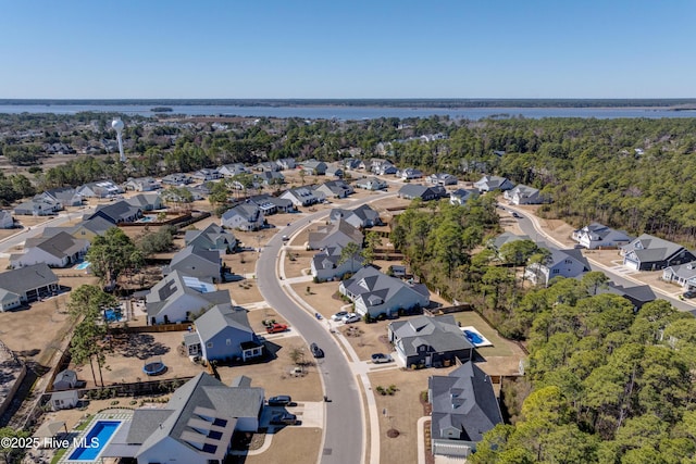 birds eye view of property featuring a water view, a residential view, and a view of trees