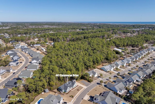 drone / aerial view with a residential view and a view of trees