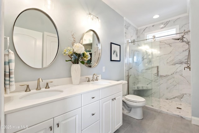 bathroom with toilet, double vanity, a marble finish shower, and a sink