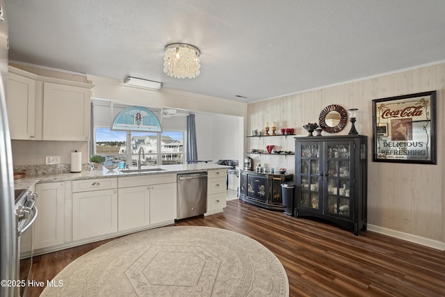 kitchen featuring dark wood-type flooring, ornamental molding, stainless steel appliances, and a sink