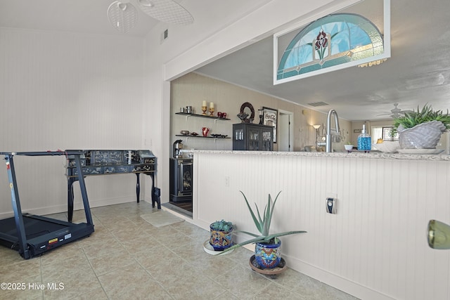 kitchen featuring crown molding, visible vents, a ceiling fan, and tile patterned floors