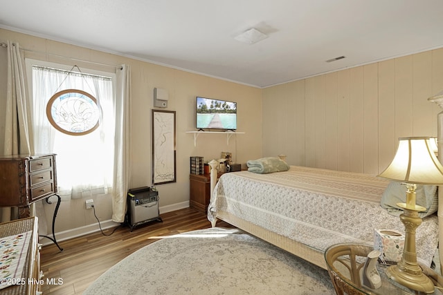 bedroom featuring ornamental molding, light wood-style flooring, multiple windows, and visible vents