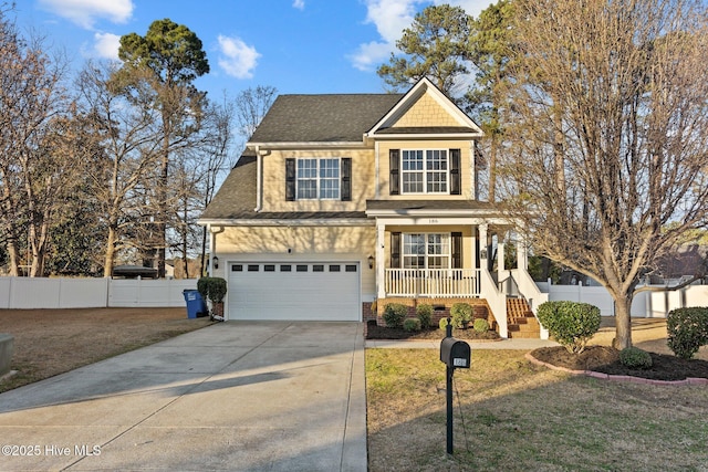 view of front facade featuring a porch, concrete driveway, fence, and a front lawn